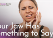 woman holding jaw in pain
